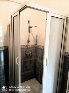 La salle de bains est pourvue d'une douche et d'une porte en verre. dans l'établissement appartement de vacances, à Kenitra