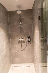 a bathroom with a shower with a glass door at Distrikt Hotels Amsterdam Zaandam in Zaandam