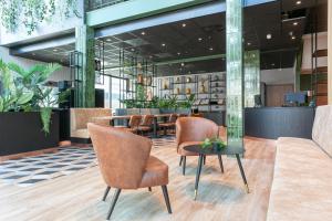 a restaurant with chairs and a table in a lobby at Distrikt Hotels Amsterdam Zaandam in Zaandam