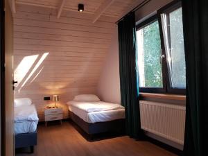 een kleine kamer met 2 bedden en een raam bij Dom nad Biebrzą - Siedlisko Wroceń 57 in Wroceń