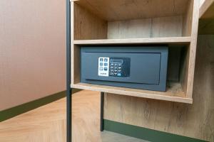 a small microwave in a shelf in a room at Distrikt Hotels Amsterdam Zaandam in Zaandam