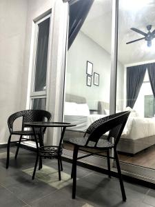 a bedroom with two chairs and a table and a mirror at Queen’s Villa for 28Pax @Central of Penang in Jelutong