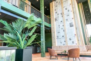 a lobby with a couch and a plant at Distrikt Hotels Amsterdam Zaandam in Zaandam