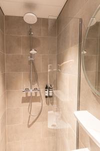 a shower with a glass door in a bathroom at Distrikt Hotels Amsterdam Zaandam in Zaandam