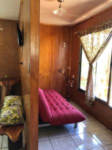 a red bench in a room with a window at Cabanas Hinariru Nui in Hanga Roa