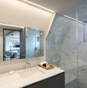 a bathroom with a sink and a glass shower at Amberes 64 in Mexico City