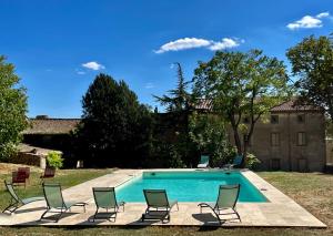 a swimming pool with lounge chairs and a swimming pool at Grande villa de vacances avec piscine - 6 chambres in Cesseras