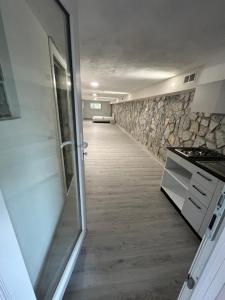 a hallway leading to a kitchen with a stone wall at Il Bunker in Bolano