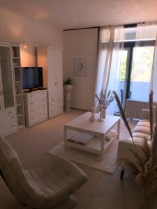 a living room with a couch and a table and a tv at Ferienwohnung Paula in Bad Harzburg