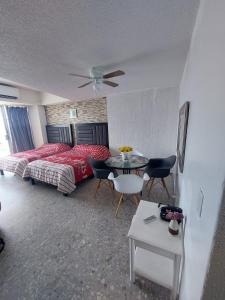 1 dormitorio con 1 cama, mesa y sillas en Suite Claus en Acapulco
