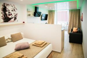 een slaapkamer met een bed en een stoel in een kamer bij Luxury Suite Borinquen with parking and swimming pool in Playa de las Americas