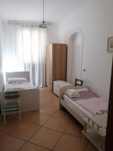 a bedroom with two beds and a chair in it at LA CASA DI MARZIA in Bardolino