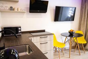 een keuken met een spoelbak en een tv aan de muur bij Luxury Suite Borinquen with parking and swimming pool in Playa de las Americas +23 foto's