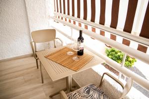 美洲海灘的住宿－Luxury Suite Borinquen，阳台上的桌子上放着两杯酒和一瓶葡萄酒