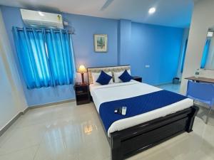 a blue bedroom with a large bed with blue walls at Classic Hotel in Shamshabad