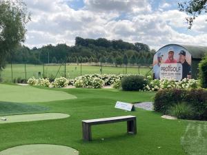 un banco sentado en medio de un campo de golf en True Hospitality en Louvain-la-Neuve