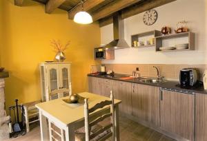 een keuken met een tafel en een klok aan de muur bij Ambar SPA. Azagalla Rural in Casas del Abad