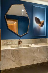 a bathroom with a large mirror and a sink at Pousada e Cerimonial Itamaraty in Pedra Azul