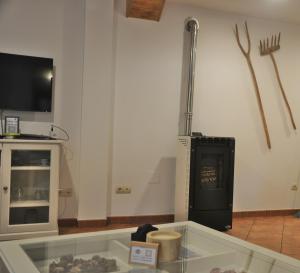 Habitación con mesa de cristal, TV y herramientas. en Casa el Tejo, en San Cristóbal de Valdueza