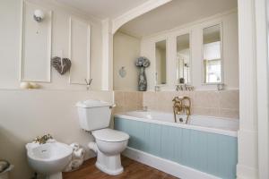 a bathroom with a toilet and a tub and a sink at Apartment 1, Durham House in Beer +18 photos