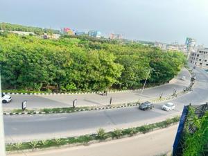 a street with cars driving down a road with trees at Classic Hotel in Shamshabad