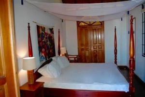 a bedroom with a large bed with a canopy at Parrot Estate Villa in Englishmanʼs Bay