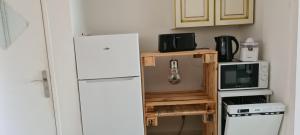 a kitchen with a white refrigerator and a microwave at T2 CARRY LE ROUET CENTRE VILLE PROCHE DE LA MER in Carry-le-Rouet