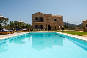 a large swimming pool in front of a building at Olivar Suites in Plitra
