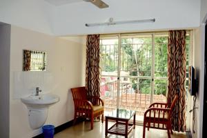 a bathroom with a sink and a toilet and a window at Uthradam towers in Trivandrum