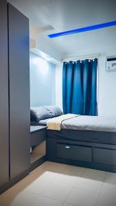 1 dormitorio con 2 camas y cortina azul en Staycation in Pasig Love Never Fails en Manila