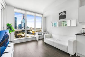 a living room with a white couch and a large window at Heart of Downtown Toronto! in Toronto