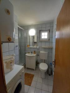 a small bathroom with a toilet and a sink at Apartment in a house among three beaches in Sutomore