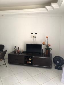 sala de estar con mesa y TV en Village Mamelucos frente para Praia do Flamengo en Salvador