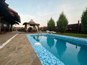 a swimming pool in a yard with a gazebo at Chervona Kalyna Cottage in Odesa