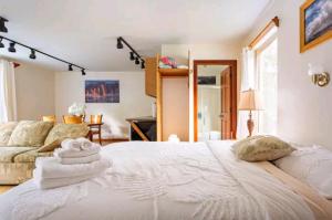 a bedroom with a large white bed and a couch at Halema'uma'u- Hale Kumu La'au in Volcano