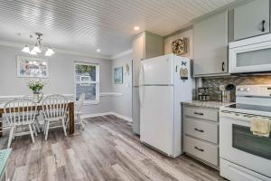 a kitchen with a white refrigerator and a table with chairs at Sparrow's Nest in Rockport
