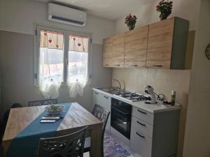 a kitchen with a table and a stove top oven at Villa Criade in Castelsardo