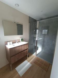 ein Bad mit einer Glasdusche und einem Waschbecken in der Unterkunft Villa en bord de mer in Jullouville-les-Pins