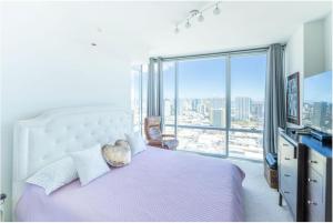 um quarto com uma cama grande e uma janela grande em Luxury Residence at Kakaako em Honolulu