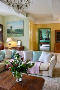 a living room with a couch and a vase of flowers at Grande villa de vacances avec piscine - 6 chambres in Cesseras