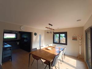 eine Küche und ein Esszimmer mit einem Holztisch und Stühlen in der Unterkunft Villa en bord de mer in Jullouville-les-Pins