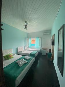 - une chambre avec 2 lits et une fenêtre dans l'établissement Pousada Hotel Canto dos Mares, à Guarujá
