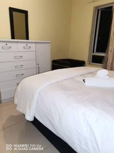 a bedroom with a white bed with a dresser and a window at Oliphant luxurious in Durban