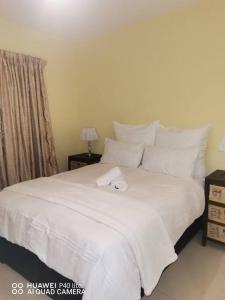 Una cama blanca con una toalla encima. en Oliphant luxurious en Durban
