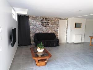 a living room with a couch and a table at Appartement Cosy chez Nicolas et Aline in Pompiey