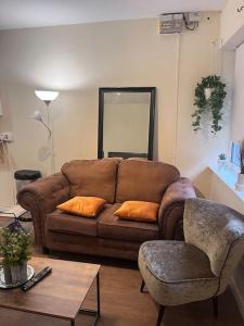 a living room with a brown couch and a table at Beautiful 1 Bedroom Maisonette in Leicester