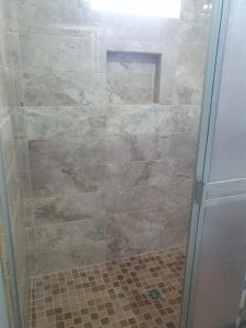 a shower with a glass door in a bathroom at HOSPEDAJE DOÑA ENEDINA in Ciudad Acuña