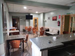 a waiting room with tables and chairs in a hospital at Hotel Dora in Plasencia