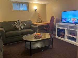 a living room with a couch and a table and a tv at Rustic Barn Style Romantic Getaway in Brampton