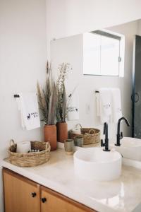 a bathroom counter with two sinks and baskets on it at Paradise Ranch Chapada dos Veadeiros in Alto Paraíso de Goiás